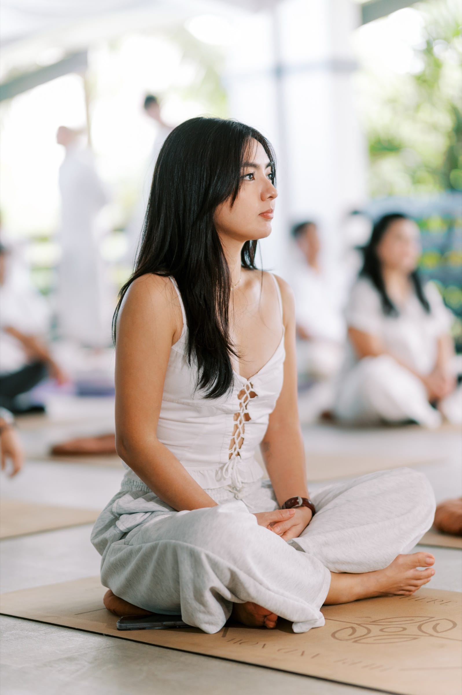 A participant seated cross-legged in quiet meditation during a morning session