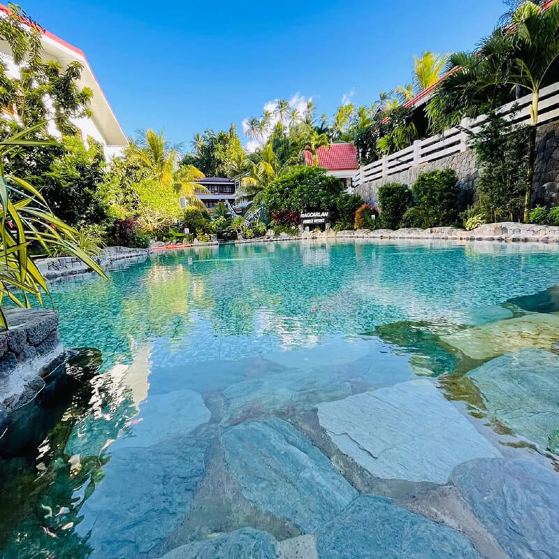 The resort's natural turquoise stone pool, surrounded by lush tropical greenery